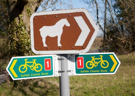 Sign for cycle route and pointing to Suffolk Punch horse tourist attraction of Easton Farm Park, at