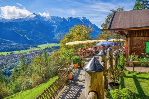St. Martinshütte with restaurant terrace above the valley in front of the Zugspitze group 2962m,