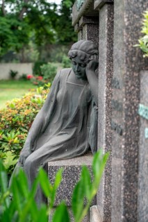 Figure in a cemetery, family grave, old gravestone, with flower and grave light, North