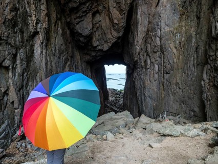 Woman with colorful umbrella, Torghatten cave, Torghatten mountain, Brønnøysund, Norway, Europe