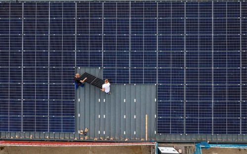 Installation of solar modules on the roof of a barn on a farm, over 210 photovoltaic modules are