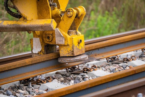 Close-up of a yellow construction machine working on a rail, track construction, Hermann Hessebahn,