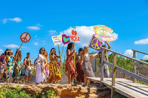 Colourfully dressed youths with musical instruments and banners form a love parade and promote the