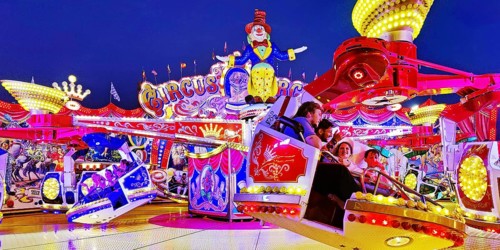 People in the illuminated carousel Circus Circus in the evening, Cranger Kirmes, Herne, Ruhr area,
