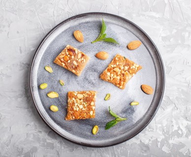 Traditional arabic sweets in gray ceramic plate on a gray concrete background. top view, close up