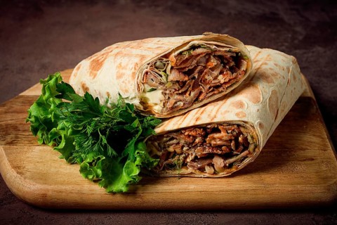 Cut shawarma, 2 pieces, on a cutting board, close-up