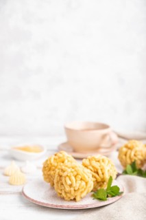 Traditional Tatar candy chak-chak made of dough and honey with cup of coffee on a white wooden
