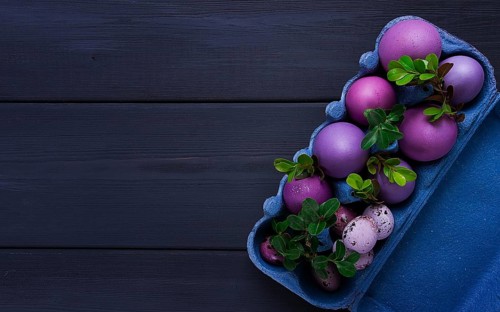 Easter eggs, purple and lilac, on a gray wooden table, Easter card, banner, selective focus,