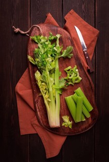 Fresh bunch of celery, top view, no people, on a dark background