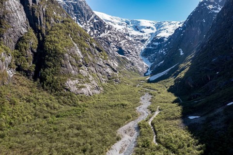 Aerial view of valley and gravel mountain road to glacier Kjenndalsbreen, valley Lodalen south of