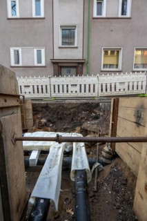 Construction site of a district heating house connection, pipes, insulated, are laid from a central
