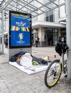 Homeless man sleeping in front of the entrance to Dortmund Central Station, North Rhine-Westphalia,