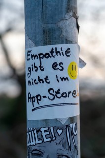 Sticker on a lamppost, empathy is not available in the app store, statement on more personal
