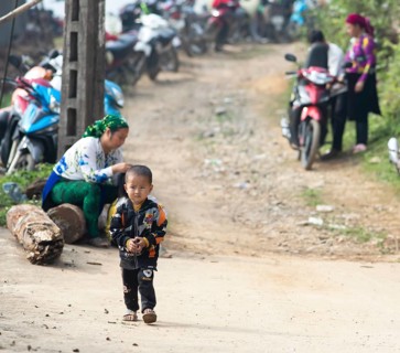 Little boy from the Hmong minority in badman jacket walking on a slope, Bac Sum village, Ha Giang