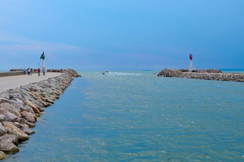 View of the sea through a narrow passage with lighthouses and rocks under a clear sky, summer, Le