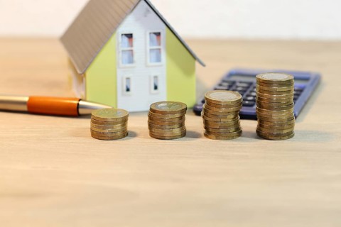 Concept photo with model house and coins