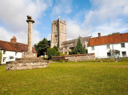 Church of St Michael and butter cross on the village green in Aldbourne, Wiltshire, England, United