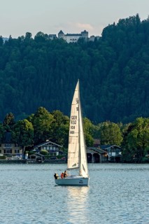 Sailing boat on Lake Tegernsee, warm evening light, above Ringberg Castle, heritage-protected
