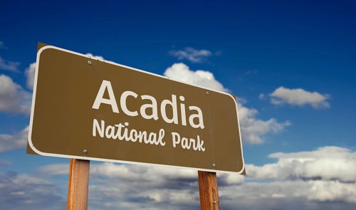 Acadia national park (maine) road sign against blue sky and clouds