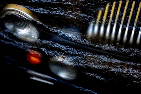 Car Lamps and Car Grille on the Front of a an Old Classic Car Covered with Plastic Protection in