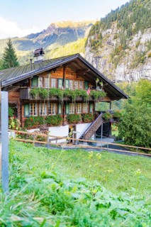 Cosy chalet with lush flowers, traditional Swiss architecture, nestled in a picturesque mountain
