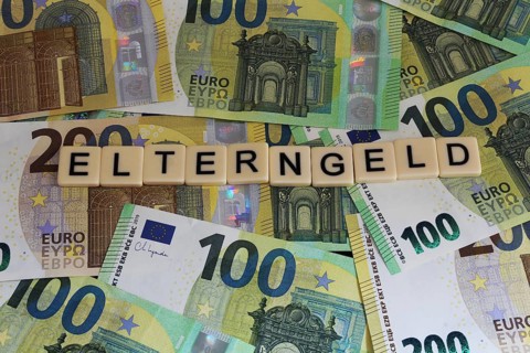 Symbolic image of parental allowance: Letters on euro notes show the word parental allowance