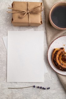 White paper invitation card, mockup with lavender, bun, cup of coffee, linen textile, box on gray