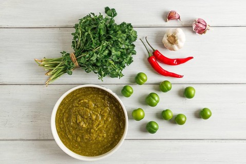 Tkemali sauce, traditional Georgian cuisine, green cherry plum, with ingredients for sauce,