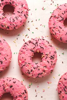 Donut with strawberries, in pink glaze, confectionery decoration, top view