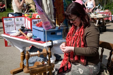 Woman demonstrating traditional spinning at a country craft event, Shottisham, Suffolk, England,