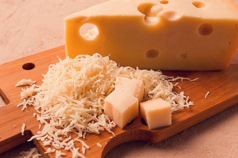 Grated cheese, Maasdam, on a cutting board, grater and cheese knife, close-up, no people