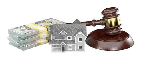 Miniature house with stack of money and wooden gavel isolated on a white background