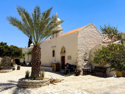 In the foreground cretan date palm (Phoenix theophrasti) behind it two-aisled church Monastery