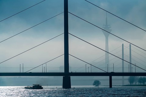 Dense fog slowly lifting, cargo ships on the Rhine near Düsseldorf, in front the Oberkassler