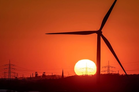 Wind turbine of the Emschergenossenschaft, view to the west, in Essen, sunset, behind the blast