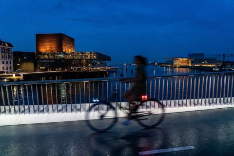 Cyclists on the Inderhavnsbroen cycle and footpath bridge, across the harbour, at night, at Nyhavn,