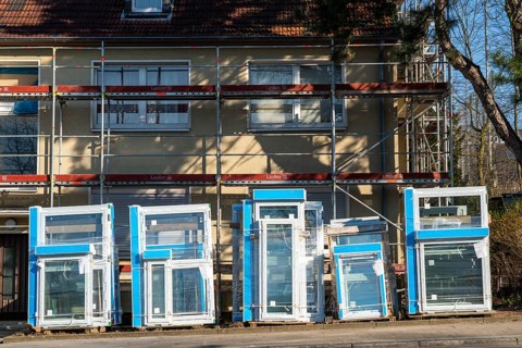 Energy-efficient refurbishment of residential buildings, older apartment block is scaffolded, gets