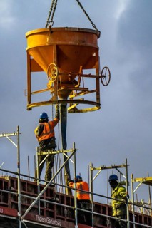 Concrete work, at dusk, on a large construction site building a residential and commercial complex,