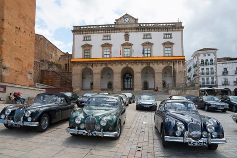 A square with a row of classic cars in front of a historic building, town hall, Ayuntamiento,