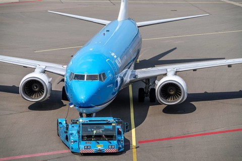 Boeing 737-800 from KLM, being driven from the terminal onto the apron, pushback, with an aircraft