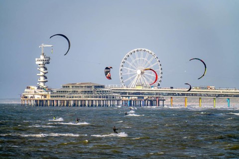 The pier and Ferris wheel at Scheveningen beach, strong swell, windsurfers, kitesurfers,