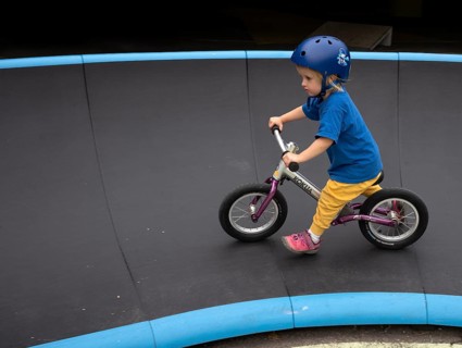 Little girl, 3 years, blonde, helmet, helmet, riding on balance bike, bicycle, skating rink,