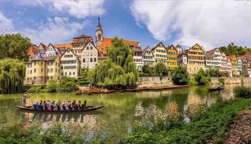 Neckarfront Tübingen with punt on the Neckar. Postcard motif with historic buildings, collegiate