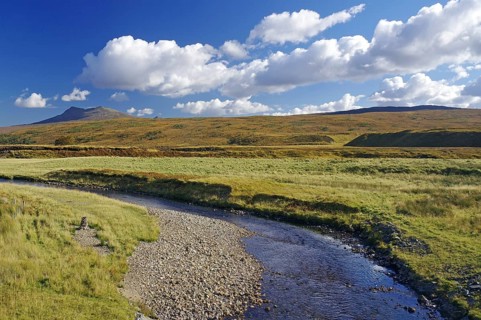 Idyllic river landscape with mountains in the background under a blue sky, autumn, October,