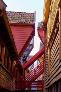 Narrow alley between old half-timbered houses with stairs, dominating wooden architecture in red