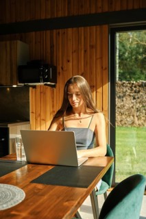 Woman looking for a recipe in internet sitting at the kitchen table