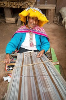 Peruvian woman in traditional traditional costume at the loom, woman's cooperative Comunidad de