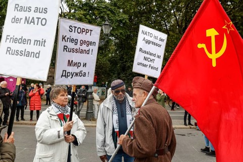 Demonstrators hold placards with slogans such as Stop war against Russia, Get out of Nato, Nato is