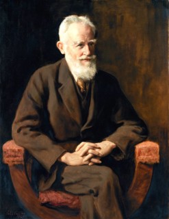 An elderly man with a beard sits in an armchair and looks thoughtful. portrait of George Bernard