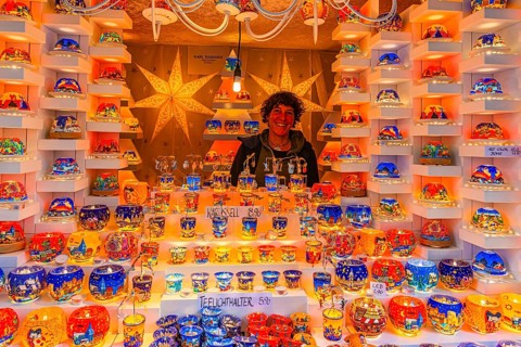 Saleswoman in a stall for tea lights at the Christmas market at St Stephen's Cathedral,